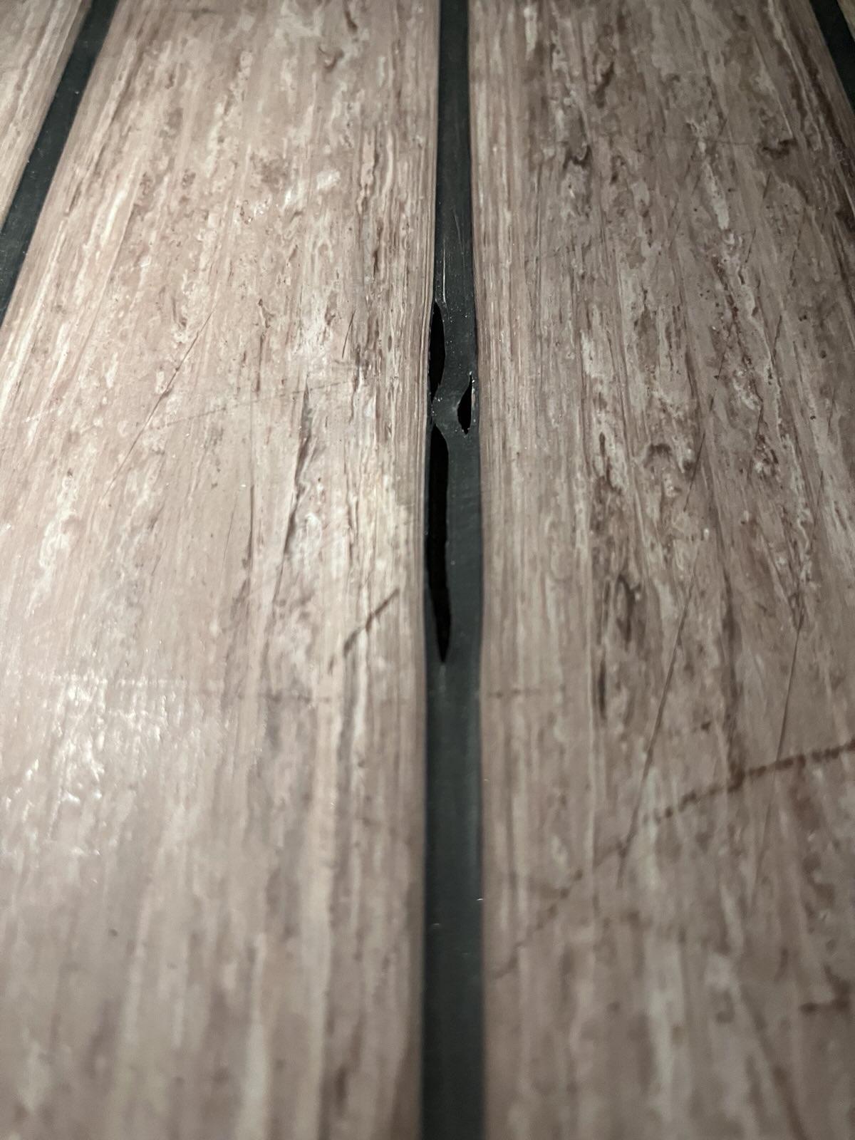 Example of cracked, low-quality caulk on a synthetic teak deck